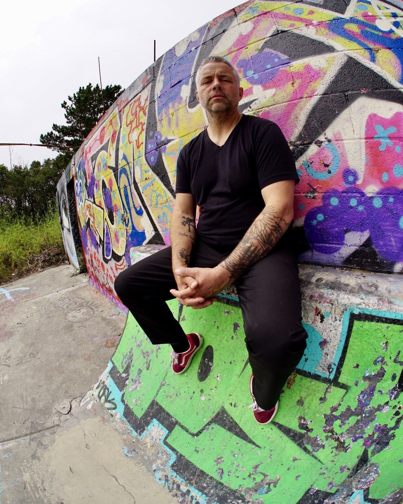 DJ RAD photographed against colorful Humboldt County street art